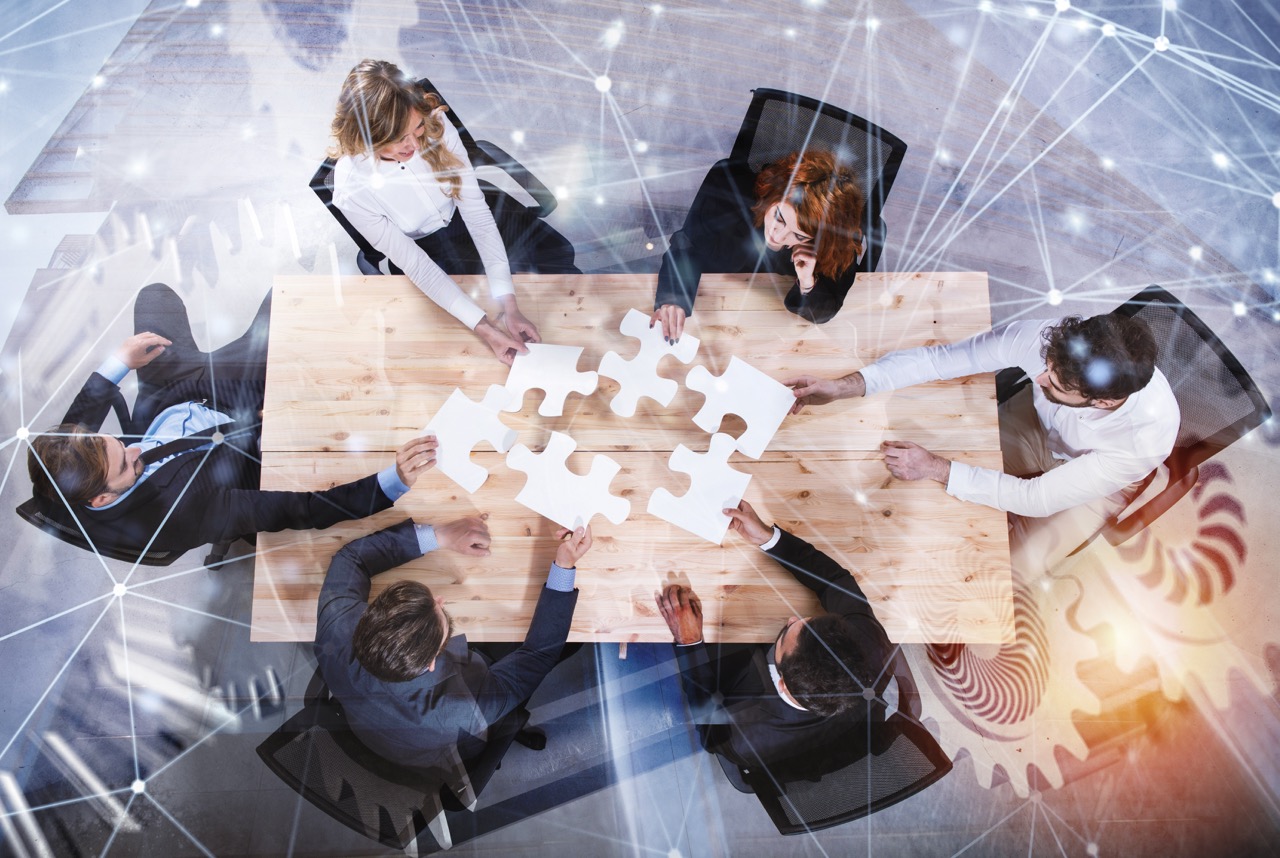 Businessmen working together to build a puzzle with gear overlay. Concept of teamwork, partnership, integration and startup. double exposure with network effects